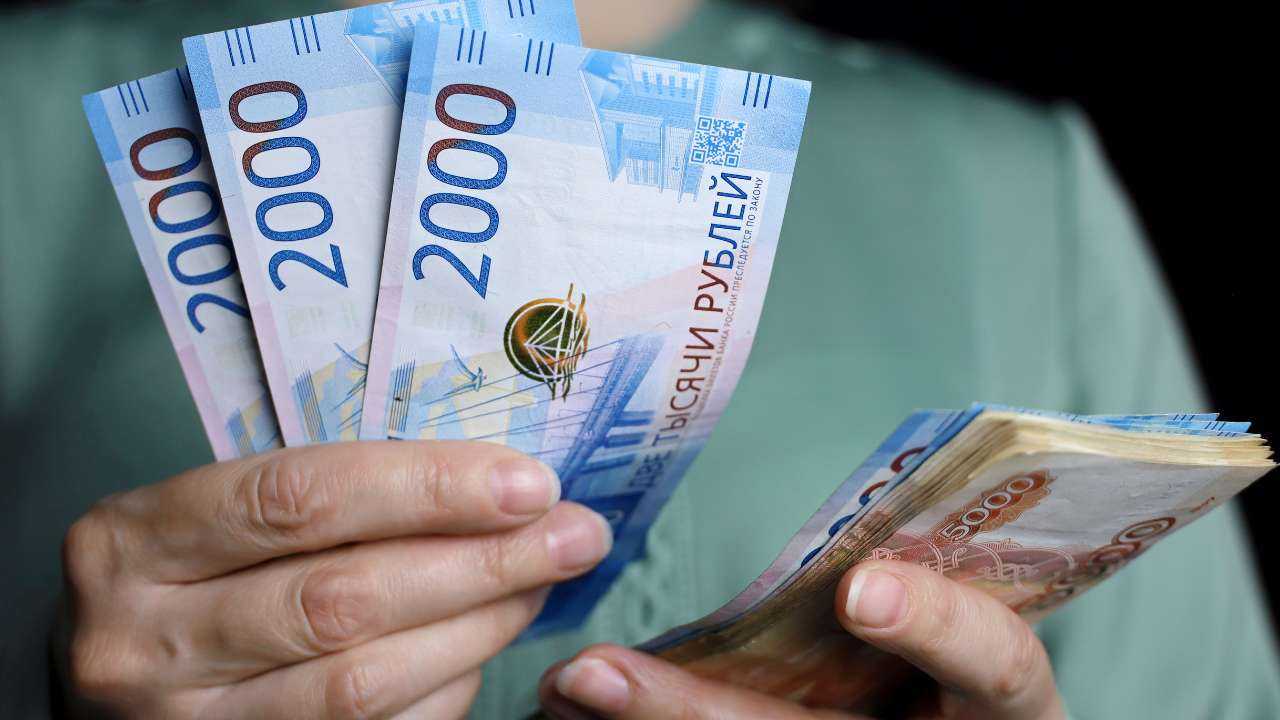В женских руках бумажные купюры по 2000 и 5000 рублей – микрозайм до зарплаты, который был получен за 15 минут