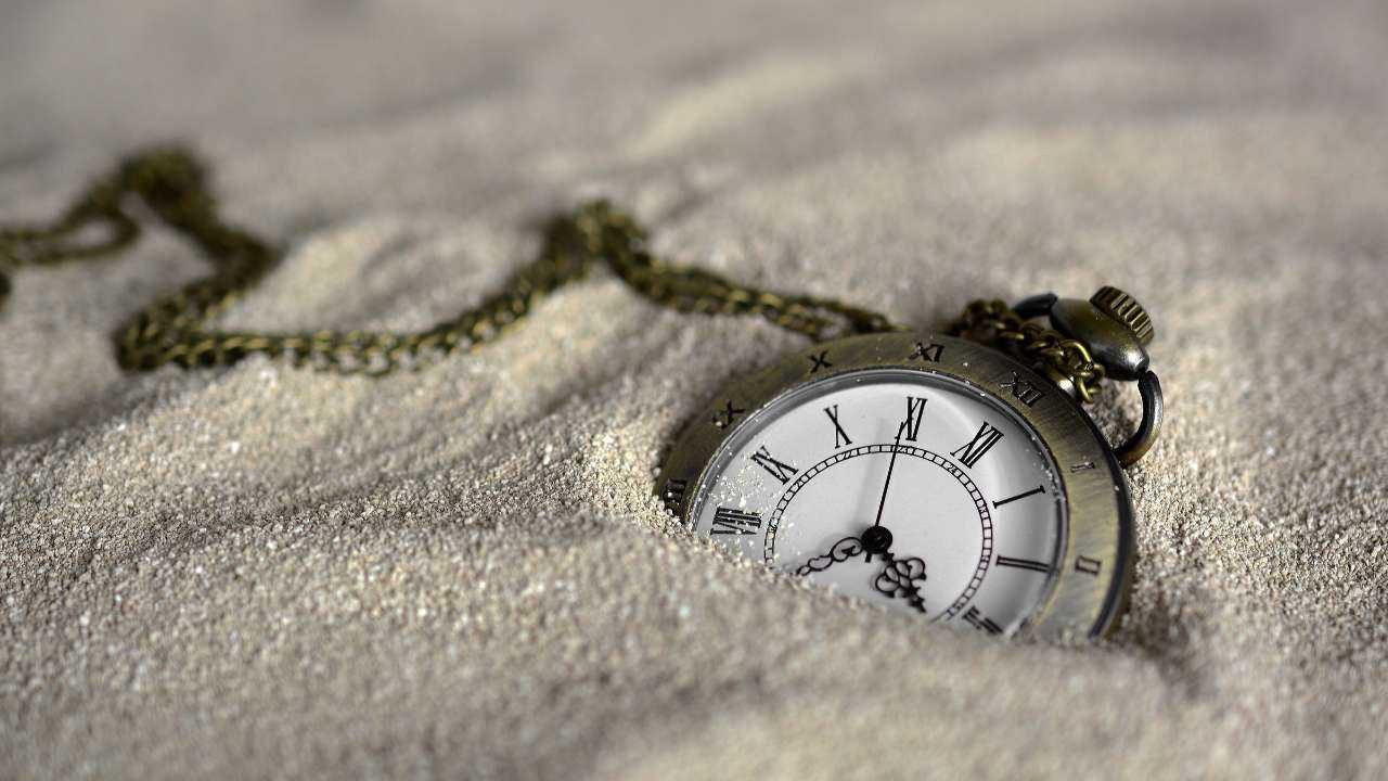 Крупным планом карманные часы в песке – композиция символизирует займы с долгосрочным погашением