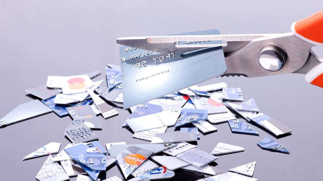 Ножницы разрезают множество кредитных карт, чтобы избежать проблем с долгами