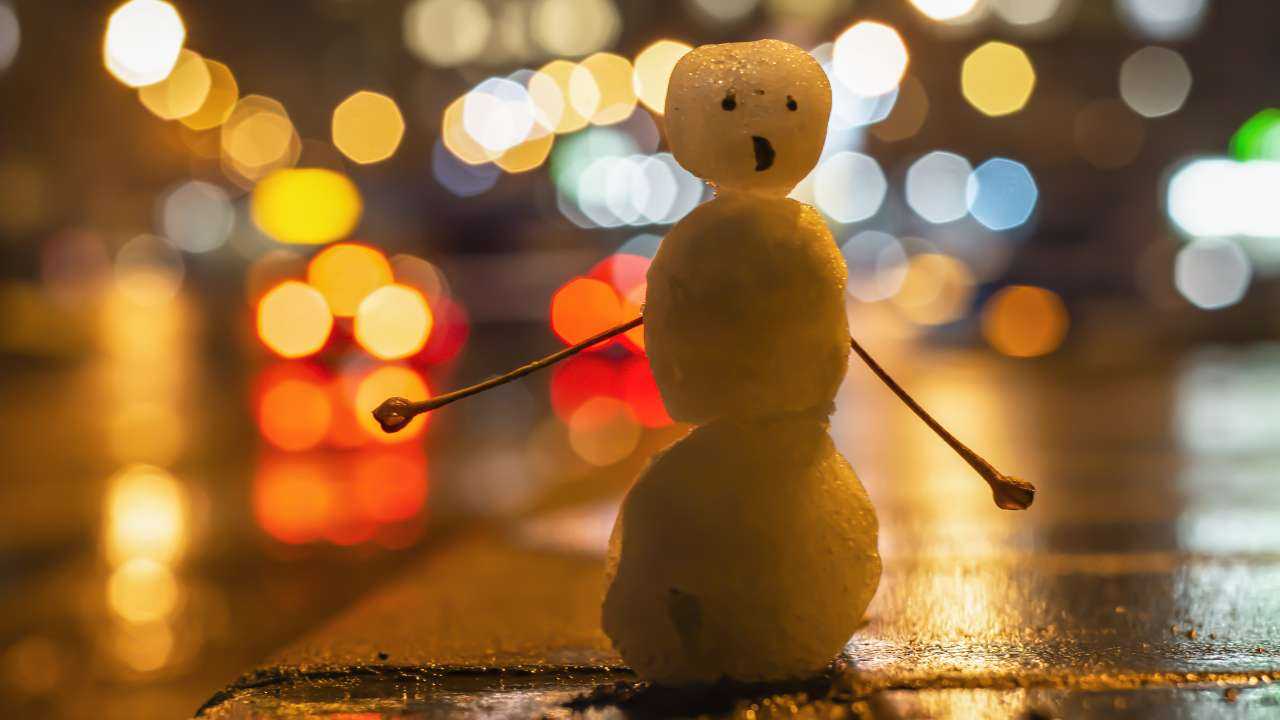 Маленький снеговик в городском свете ночи, олицетворяющий финансовый гороскоп на февраль 2024 года